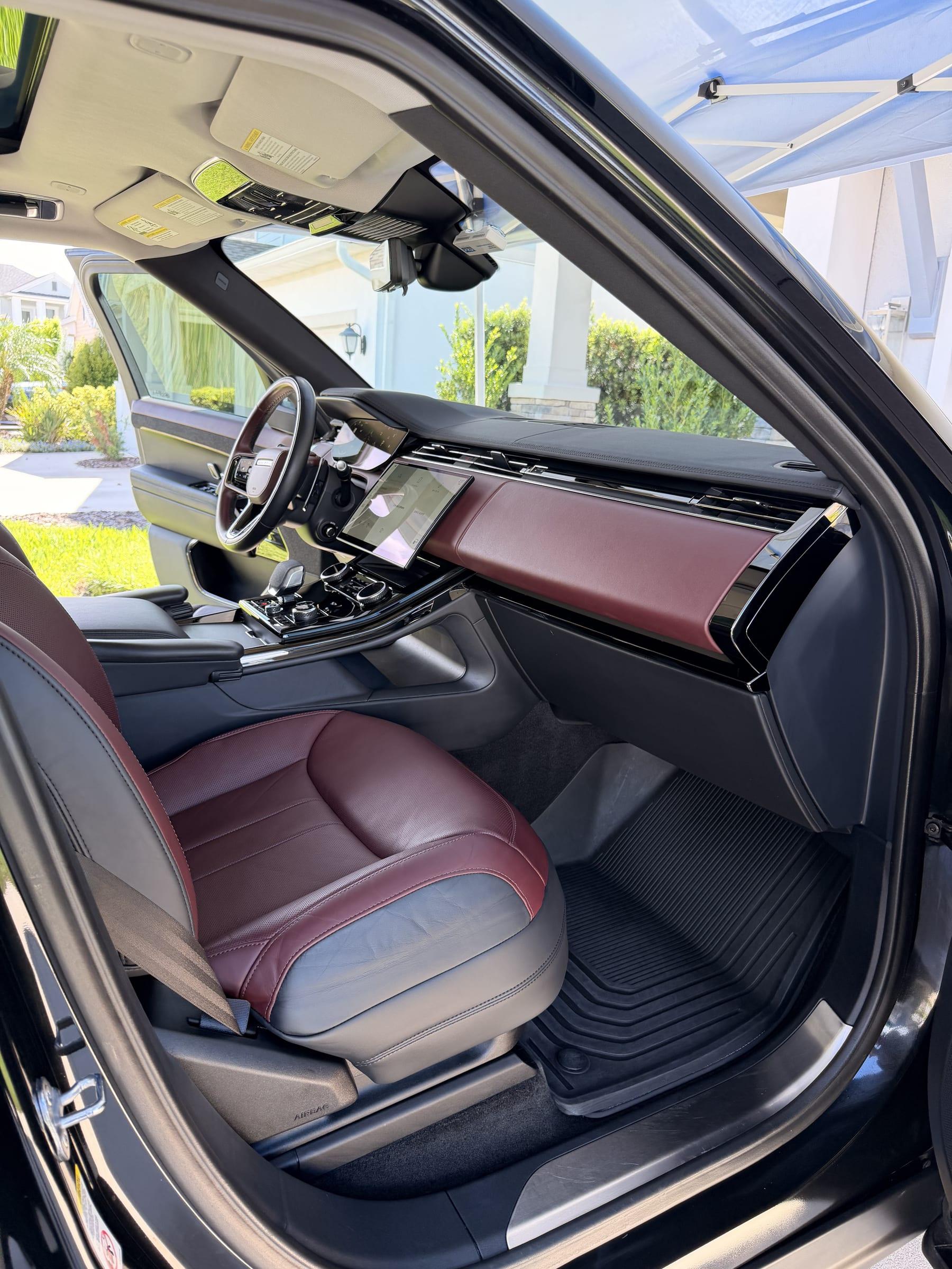 Range Rover front cabin after an interior detail — burgundy leather seats, dashboard and screens cleaned